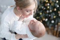 Happy mother with her young son on Christmas Eve near the Christmas tree Royalty Free Stock Photo