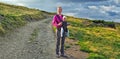 Happy mother hold baby boy 7 months on back in baby carrier walking in Carpathian Mountains Royalty Free Stock Photo