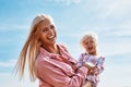 Happy mother holding baby smiling on a wheat field in sunlight Royalty Free Stock Photo