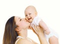 Happy mother holding on hands and kissing her cute baby Royalty Free Stock Photo