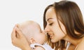 Happy mother holding on hands and kissing her little sleeping baby on a white background Royalty Free Stock Photo