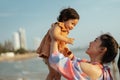 happy mother holding and lifting with toddler baby girl on the sea beach Royalty Free Stock Photo