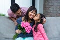 Happy mother holding roses being kissed by her daughter Royalty Free Stock Photo