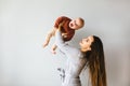 Happy mother holding up her baby girl. Young beautiful mother holds her baby and cuddles, motherhood concept. Royalty Free Stock Photo