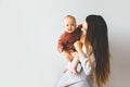 Happy mother holding up her baby girl. Young beautiful mother holds her baby and cuddles, motherhood concept. Royalty Free Stock Photo