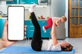 A happy mother holds a baby in her arms while having fun doing fitness together on a mat. A woman& x27;s hand on the left Royalty Free Stock Photo