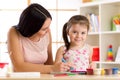 Happy mother and kid daughter painting with pencils Royalty Free Stock Photo