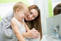 Happy mother and kid washing hands with soap in