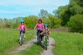 Happy mother and kids on bikes cycling outdoors