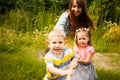 Happy mother and kids playing tug of war in park Royalty Free Stock Photo