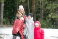 Happy mother, kids and spaniel in winter forest. Family trip out of town. Woman warm up under blankets son and puppy. Royalty Free Stock Photo