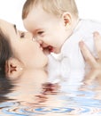 Happy mother kissing baby boy in water Royalty Free Stock Photo