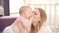 Happy mother kissing baby. Young mother cuddling baby Royalty Free Stock Photo