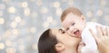 Happy mother kissing her baby over lights Royalty Free Stock Photo