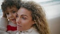 Happy mother kissing son on autumn beach closeup. Cute curly kid having fun Royalty Free Stock Photo