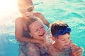 Happy mother laughing with sons in swimming pool