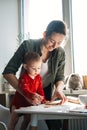 Happy mother and little baby toddler girl making christmas cookies in home kitchen. Mother and little girl baking Royalty Free Stock Photo