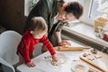 Happy mother and little baby toddler girl making christmas cookies in home kitchen. Mother and little girl baking Royalty Free Stock Photo