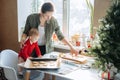 Happy mother and little baby toddler girl making christmas cookies in home kitchen. Mother and little girl baking Royalty Free Stock Photo