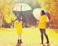 Happy mother and little child with colorful umbrella in sunny autumn park Royalty Free Stock Photo