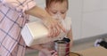 happy mother and little child girl sieving flour into bowl.