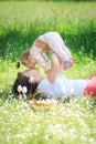 Happy mother and little child hugging kissing in spring park on nature. Mom throws her beloved healthy daughter up in Royalty Free Stock Photo