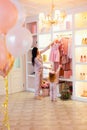 Happy mother and little child staying near wardrobe with dresses on hangers Royalty Free Stock Photo