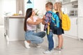 Happy mother and little children with school bags