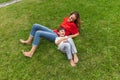 Happy mother and little cute son strolling at street, public park in summer time, outdoors. Family time, togehterness