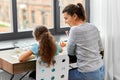 happy mother with little daughter drawing at home