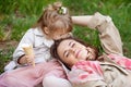 Happy Mother and little Daughter outdoor portrait. Mom and her child enjoying nature together in green park, kissing and hugging, Royalty Free Stock Photo