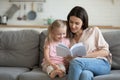 Happy mother and little daughter reading book together at home Royalty Free Stock Photo