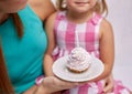 Happy mother and little girl holding cupcake Royalty Free Stock Photo