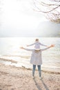 Happy mother and little girl standing near lake with open arms on a beautiful sunny day Royalty Free Stock Photo