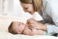 Happy mother looking at baby in bedroom