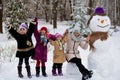 Happy mother of many children sculpt a big real snowman Royalty Free Stock Photo