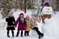 Happy mother of many children sculpt a big real snowman Royalty Free Stock Photo