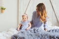 Happy mother and 9 month old baby in matching pajamas playing in bedroom in the morning Royalty Free Stock Photo