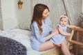 Happy mother and 9 month old baby in matching pajamas playing in bedroom in the morning Royalty Free Stock Photo