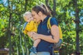 Happy mother playing with baby in the park in autumn. Kid smiling at mum on hands at the park in autumn Royalty Free Stock Photo