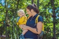 Happy mother playing with baby in the park in autumn. Kid smiling at mum on hands at the park in autumn Royalty Free Stock Photo