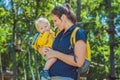 Happy mother playing with baby in the park in autumn. Kid smiling at mum on hands at the park in autumn Royalty Free Stock Photo