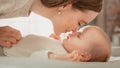 Happy Mother Playing with a Cute Newborn Baby. Mom Bonding with a Toddler, Rubbing Belly, Kissing Royalty Free Stock Photo