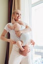 Happy mother playing with her baby son at home holding infant upside down. Family having fun Royalty Free Stock Photo