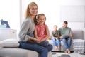 Happy mother playing with her daughter while father and son using laptop at home Royalty Free Stock Photo