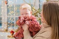 A happy mother plays with a baby in her arms at home not against the background of a decorated room and a Christmas tree Royalty Free Stock Photo