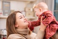 A happy mother plays with a baby in her arms at home not against the background of a decorated room and a Christmas tree Royalty Free Stock Photo