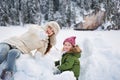 Happy mother pointing in camera to child while playing outdoors Royalty Free Stock Photo