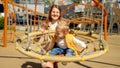 Happy mother pushing swing with her baby son on playground. Children playing outdoor, kids outside, summer holiday and vacation Royalty Free Stock Photo
