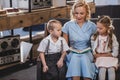 happy mother reading book while sitting with adorable little kids on sofa at home 50s Royalty Free Stock Photo